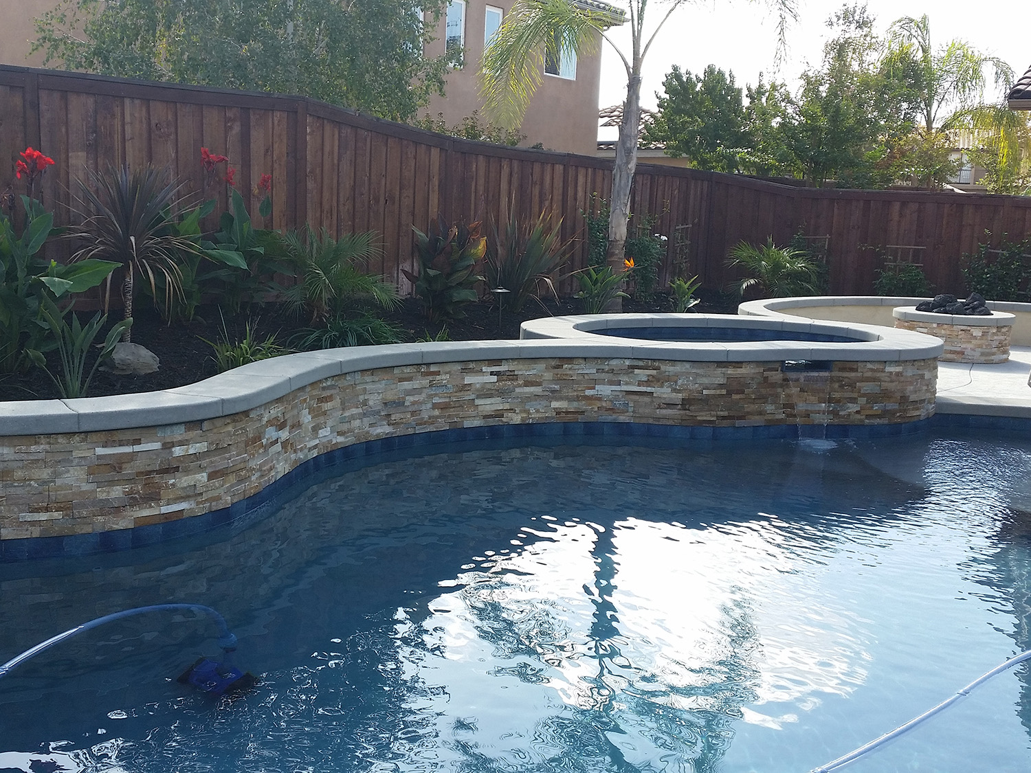 Pool and spa, fireplace, tropical plantings, stone work